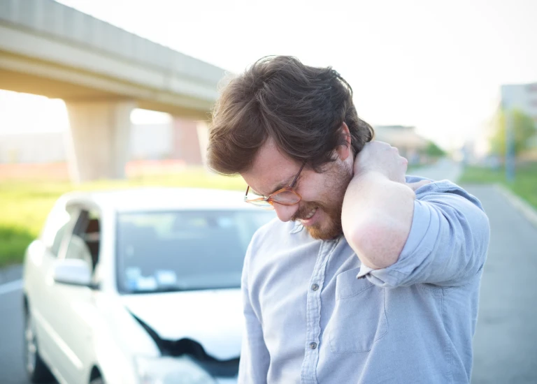 a man talking on a cell phone next to a car